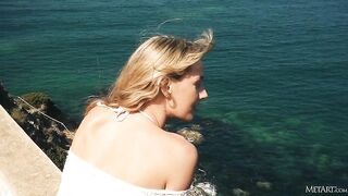 Девушка в купальнике красиво раздевается с видом на Средиземное море