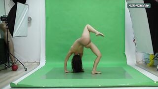 Голая гимнастка виртуозно позирует, выступая в фотостудии с обручем