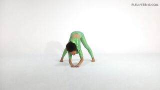 Загорелая гимнастка тянется в латексе и голышом на коврике для йоги